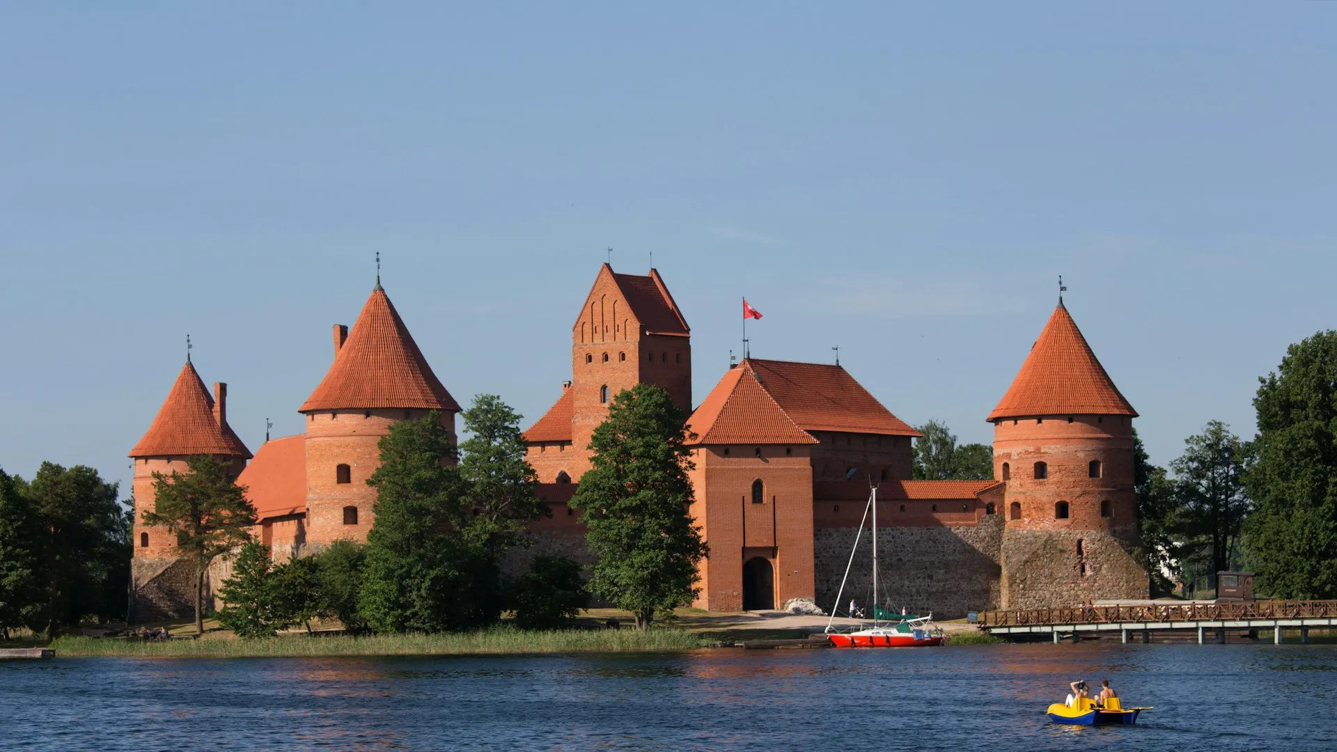 Trakai Island Castle with red brick towers reflected in Lake Galvė, Lithuania